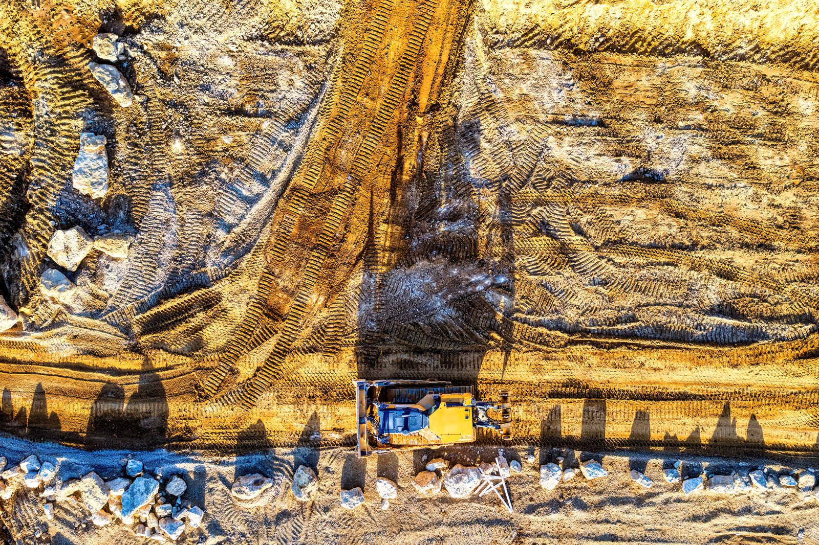 Aerial stock photograph of earthmoving equipment and tracks at a worksite